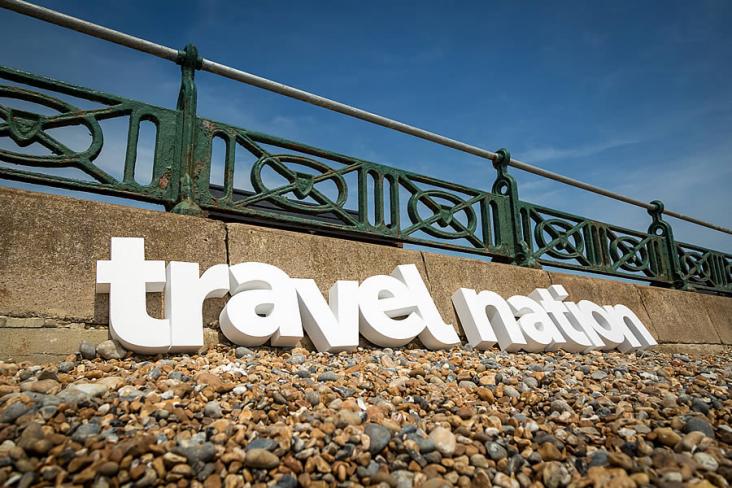 Travel Nation logo on the beach