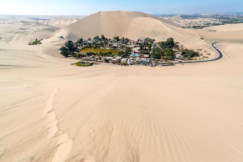Sandboard down the giant dunes surrounding the oasis of Huacachina