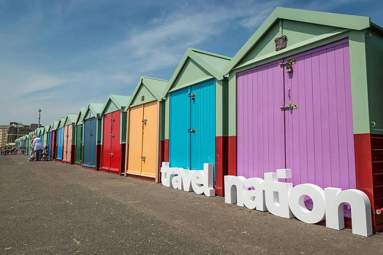 Brighton beach huts with Travel Nation logo letters