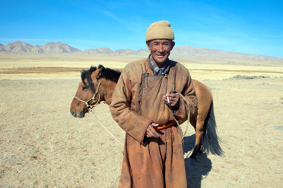 A Nomadic horseman moves across the vast Mongolian Steppe 